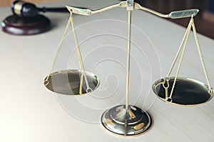 Close up of scales of justice and gavel on wooden table in a courtroom striking, Law and justice concept