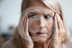 Close up of scared elderly woman having panic attack