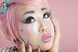 Close-up of scared young woman over pink background