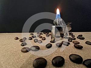 Close-up of Scatterred coffee beans in a horizontal line with matches on a black background