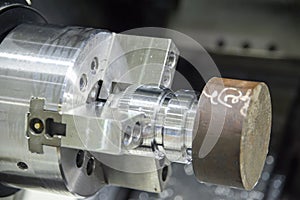 Close-up scene of the CNC lathe machine chucking the metal rod parts .