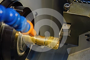 Close up scene the CNC lathe machine thread cutting at the end of brass pipe coupling parts