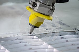 Close-up scene of multi-axis waterjet cutting machine cutting the aluminum plate photo