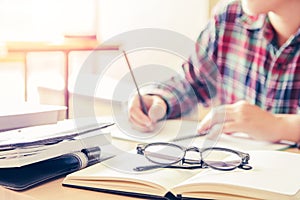 Close- up.School student holding pencil taking exams writing in classroom for education concept