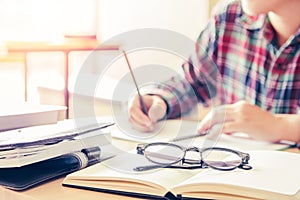 Close- up.School student holding pencil taking exams writing in classroom for education concept photo