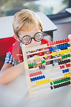 Close-up of schoolkid counting abacus in classroom