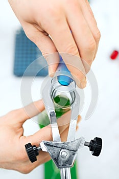 Close up of scientist filling test tubes in lab