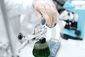 Close up of scientist filling test tubes in lab