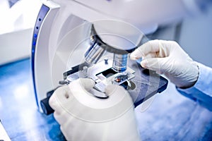 close-up of scientist hands with microscope, examining samples photo