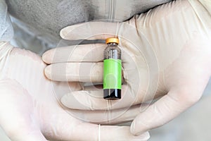 Close up of scientist holding bottle of vaccine developed for corona virus. Covid-19 antidote. Doctor discovers treatment for