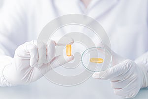 Close up Scientist holding capsule gel in labcoat