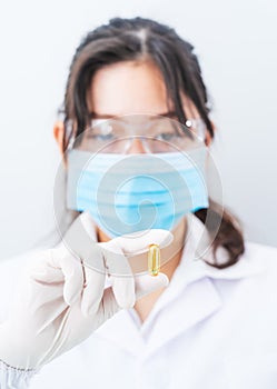 Close up Scientist holding Omega 3 capsule in labcoat