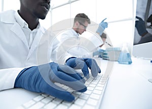 Close up.scientist typing on computer keyboard.