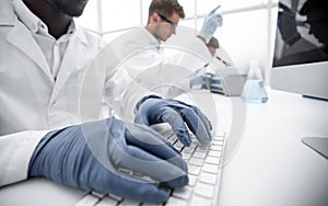 Close up.scientist typing on computer keyboard.