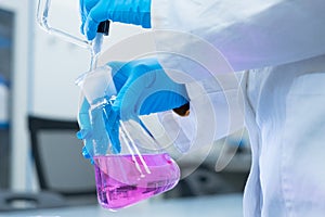 Close up scientist uses a titration method of analysis to study chemical properties of the water sample. Scientist