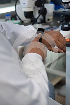 Close-up of a scientist using a smartwatch in the lab