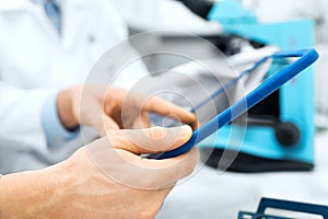 Close up of scientists hands with tablet pc in lab