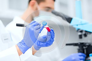 Close up of scientists hands with test tube in lab