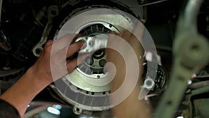 Close up screwing bolts on a car clutch disk.