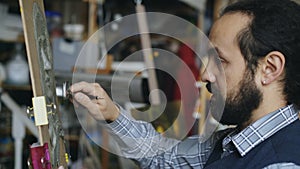 Close-up of Sculptor creating sculpture of woman`s face on canvas in art studio