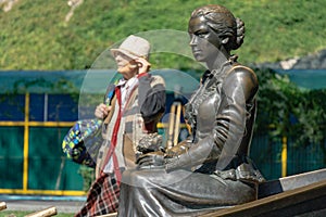 Close-up of sculpture Aksinya and blurred elderly woman on embankment of Rostov-on-Don