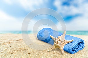 Close-up sea star with towel on sandy beach at