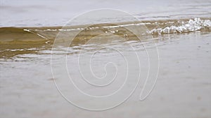 Close up for the sea water waves on a sandy beach, natural background. Stock footage. Small waves washing up the