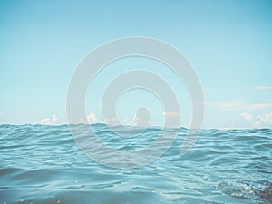 Close up of sea wave. Front view on beautiful sea wave on sandy beach. Summer sunny day, blue sky, water background