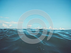 Close up of sea wave. Front view on beautiful sea wave on sandy beach. Summer sunny day, blue sky, water background