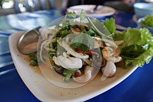 Close-up seafood, mixed seafood salad with various vegetables and herbs, Asian popular food.
