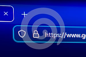 Close-up of a secure web browser address bar with HTTPS protocol, padlock icon, and shield symbol, representing internet