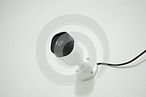 Close-up of a security camera mounted on a wall in a modern office, ready to be used