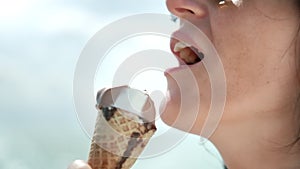 Close-up seductive travel woman licking ice-cream by tongue at sunny sea natural background