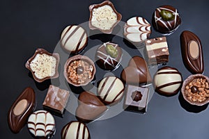 Close up of a selection of luxury chocolates, with a variety of shapes including a heart, florentines, and pistachios.
