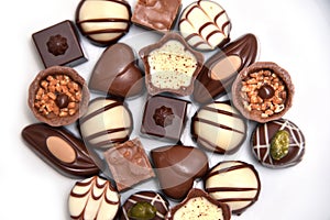 Close up of a selection of luxury chocolates, with a variety of shapes including a heart, florentines, and pistachios.