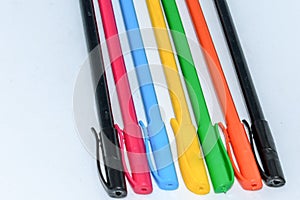 Close-up selection of Multi Colored Boll pint pens, close together in a row arrangement in white background, flat lay. Horizontal