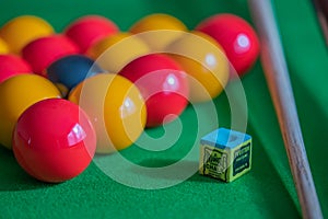 Pool balls, chalk and cue on a pool table