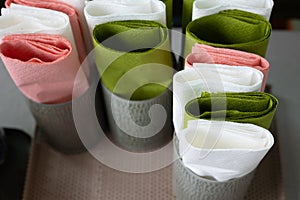 Close up and selective focus with copy space shot of colorful paper napkins folded in many cup containers prepared for restaurant