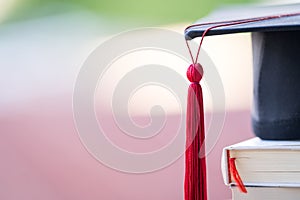 Close-up selective focus of a graduation cap or mortarboard and diploma degree certificate put on table