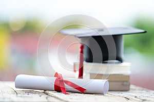 Close-up selective focus of a graduation cap or mortarboard and diploma degree certificate put on table