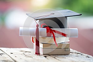 Close-up selective focus of a graduation cap or mortarboard and diploma degree certificate put on table