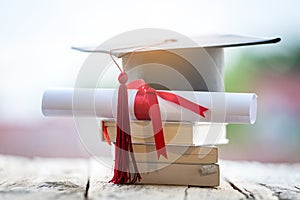 Close-up selective focus of a graduation cap or mortarboard and diploma degree certificate put on table