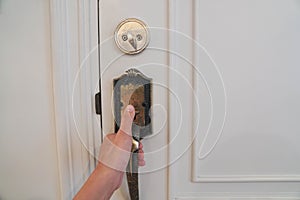 close up selective focus hand hold vintage doorknob to lock the hotel room