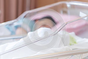 Close up and Selective focus of newborn baby boy and new mother sleeping in a hospital