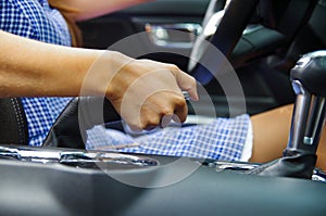 Close up of selective focus of woman s hand actioning a hand brake inside of her car, standing on the sidelines