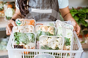 Close up of a seller carries a basket of vegetables