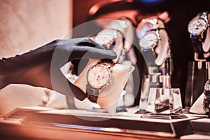 Close-up of the seller`s hand in gloves shows the exclusive men`s watch from the new collection