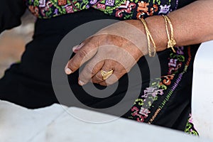 Close up of senior Arab woman hands with jewelry.