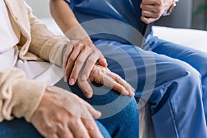 Close-up senior Asian woman hand with her caregiver helping hands, Caregiver visit at home. Home health care and nursing home