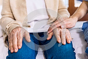 Close-up senior Asian woman hand with her caregiver helping hands, Caregiver visit at home. Home health care and nursing home